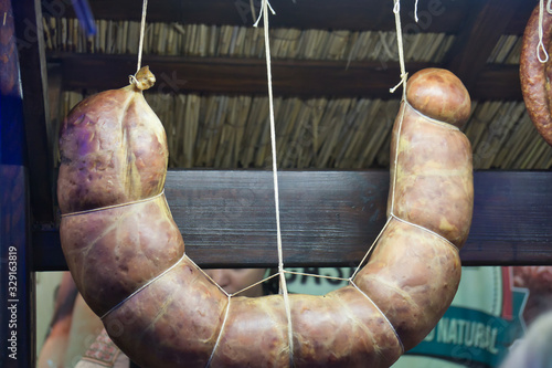 Smoked and homemade sausages hanging at an outdoor market