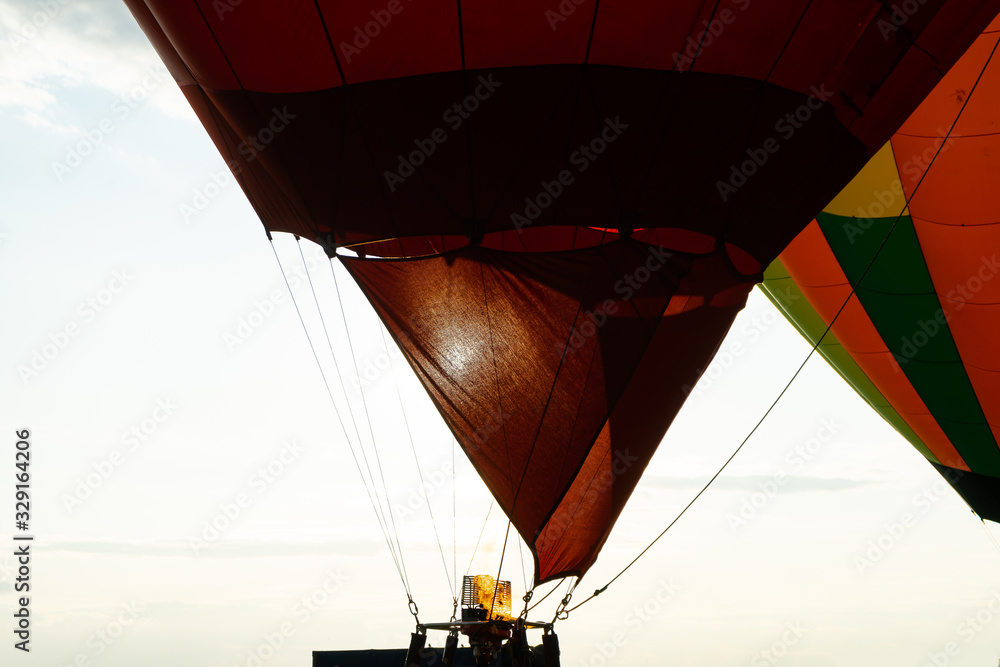 Obraz premium Fire warms the air in a balloon. Balloonists prepare the balloons for flight. Festival of aeronautics.