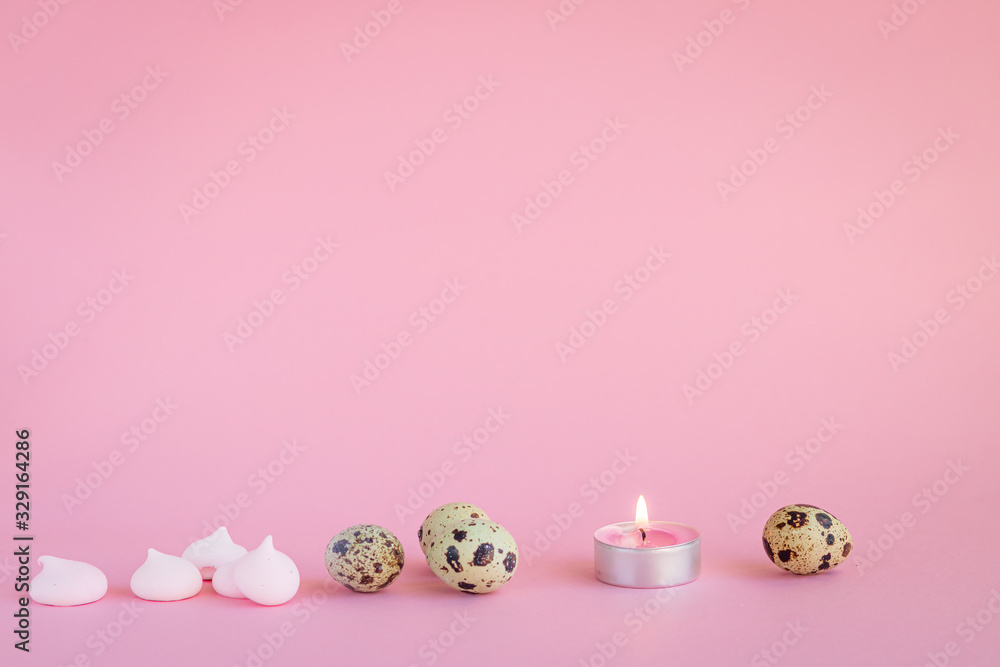 Festive still life made of quail eggs, candle and meringue on the pink background. Copy space. Holidays concept.  