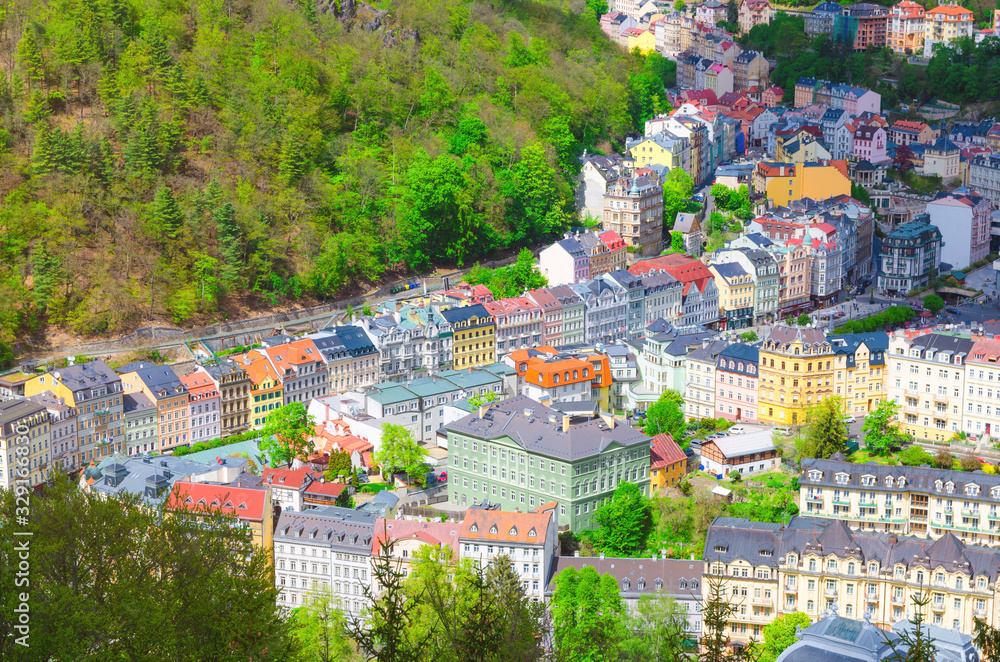 Karlovy Vary (Carlsbad) historical city centre top aerial view with colorful beautiful buildings, Slavkov Forest hills with green trees on slope, close-up, West Bohemia, Czech Republic