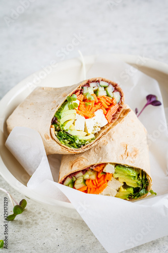 Cuadro en lienzo Vegan tortilla wraps with tofu, cucumber, carrots and avocado.
