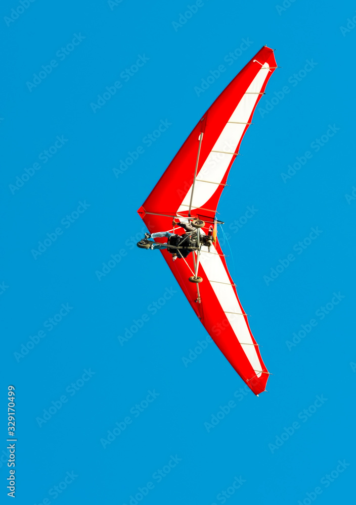 Naklejka premium The motorized hang glider in the blue sky