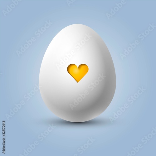 Cute white egg with a yellow heart in the shell, easter or valentine's egg, concept of newborn and pregnancy