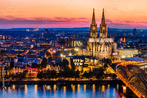 Beautiful night landscape of the gothic Cologne cathedral  Hohenzollern Bridge and the River Rhine at sunset and blue hour in Cologne  Germany