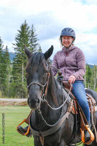 A young woman riding a horse, part of horse, front view in Banff national park