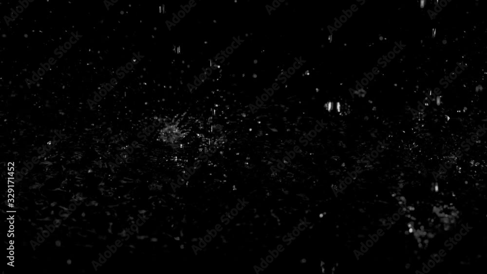 Droplets of rain falling on the surface creating splashes on an isolated background Droplets of rain falling on the surface creating splashes on an isolated background