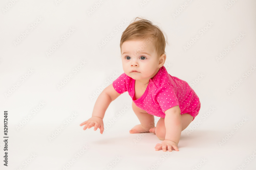 healthy baby girl in a pink bodysuit sits on a white background. space for text healthy baby girl in a pink bodysuit sits on a white background. space for text