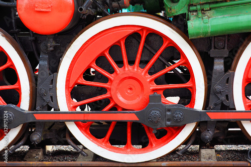 Steam locomotive, rod drive of a old locomotive. Red wheels of a steam train