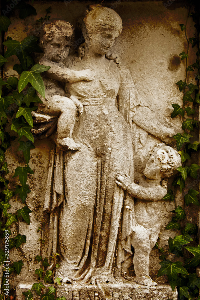 Antique statue of Woman with children with description on Latin: Haritas (Сharity).