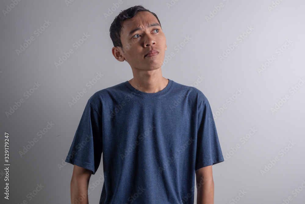 a Young Asian man who is confused thinking about something