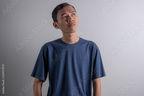 a Young Asian man who is confused thinking about something