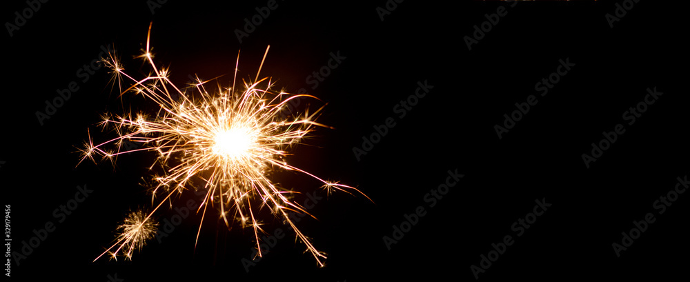 Silvester festive background - Sparkler in the dark black night, with space for text