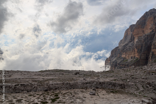 Material ropeway to alpine hut Rifugio Alimonta and mountain alps panorama with clouds in Brenta Dolomites, Italy