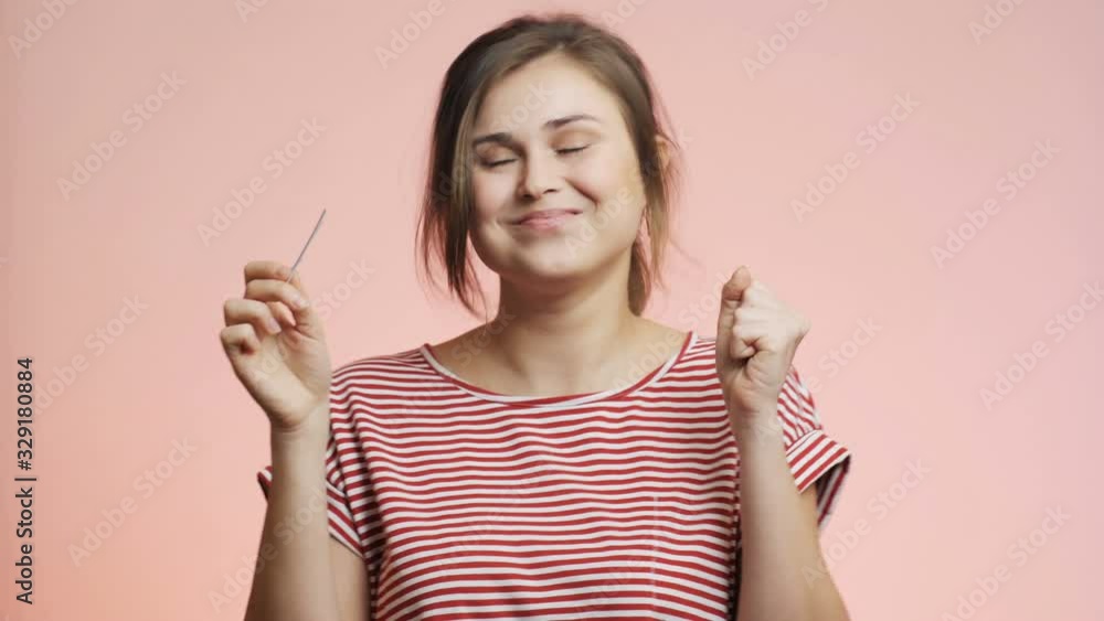young woman on pink studio background checking result of a medical pregnancy test, girl delighted, screaming from happiness looking up and thanks to God, family planning concept young woman on pink studio background checking result of a medical pregnancy test, girl delighted, screaming from happiness looking up and thanks to God, family planning concept