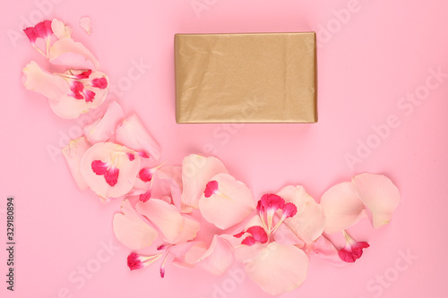 Top view of gift boxes, flowers petals isolated on pink with copy space © SYARGEENKA