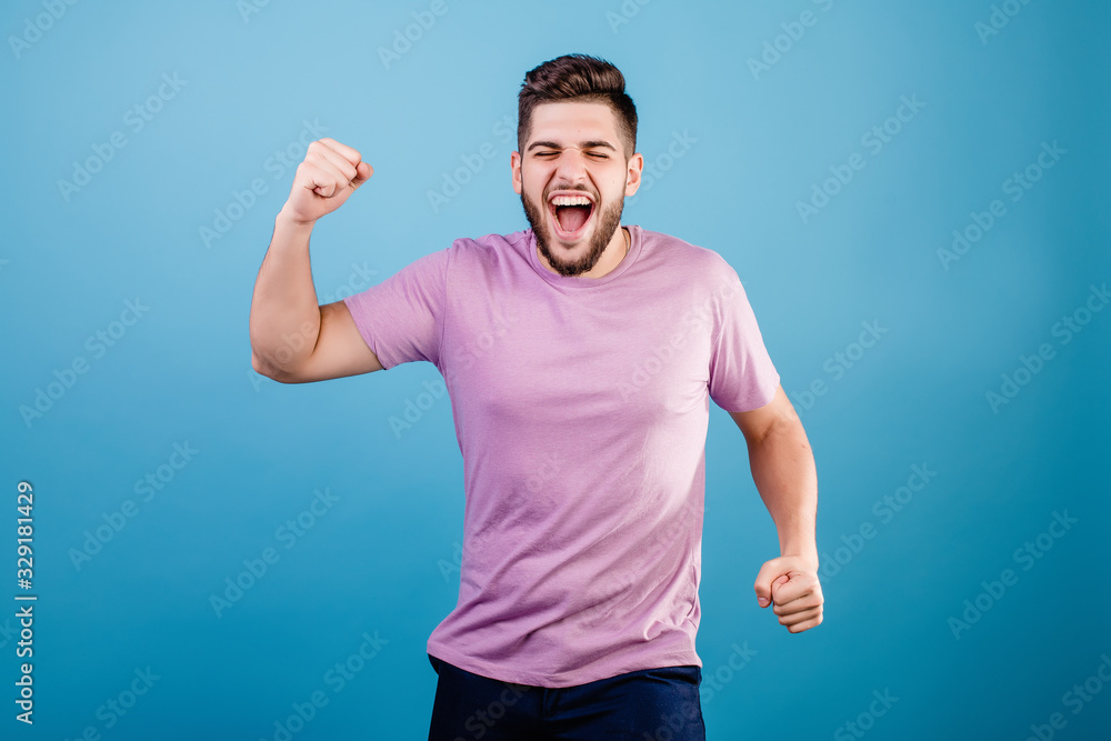 excited happy man shaking hands smiling isolated on blue background excited happy man shaking hands smiling isolated on blue background