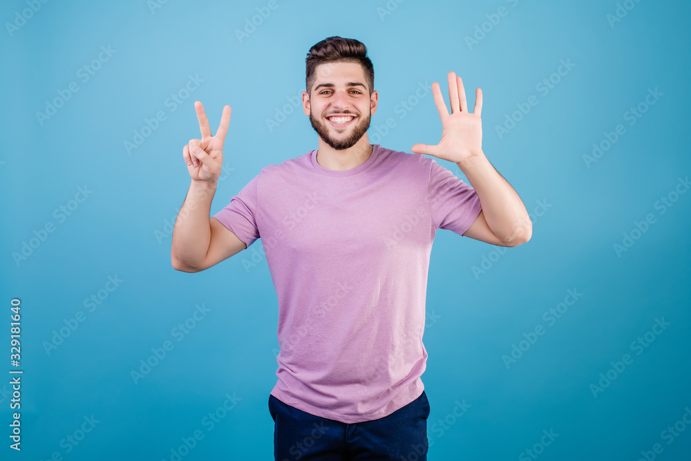 smiling man showing seven fingers isolated on blue background smiling man showing seven fingers isolated on blue background