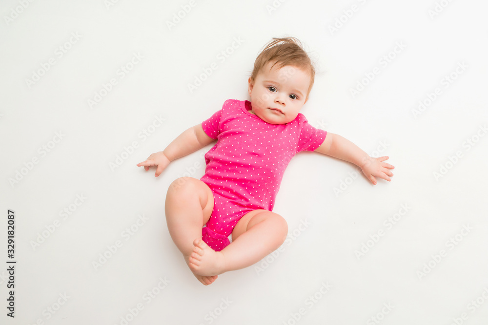 healthy baby girl in a pink bodysuit sits on a white background. space for text healthy baby girl in a pink bodysuit sits on a white background. space for text