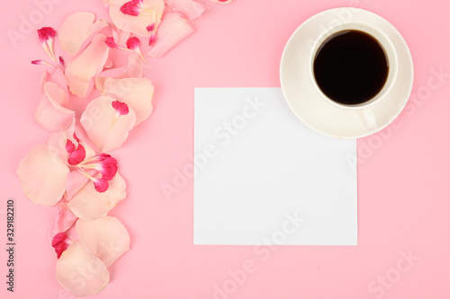 Creative flat lay with coffee cup and flowers. Womens freelancer and business concept. Pink background