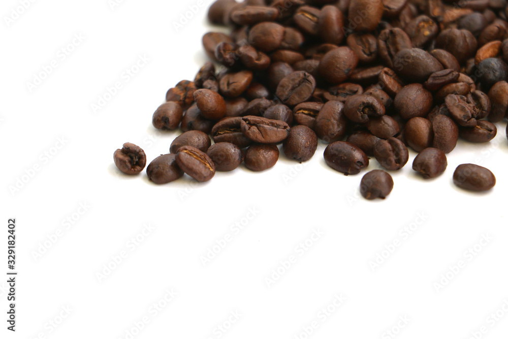 Isolated coffee beans scattered on a white surface with space for text Isolated coffee beans scattered on a white surface with space for text
