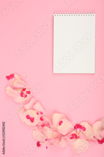 Styled flat lay mockup with floral elements on pink table. Copy space. © SYARGEENKA