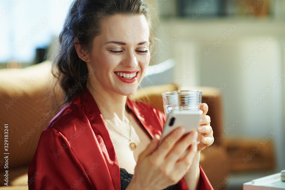 woman with cup of water with smartphone hanging in social media woman with cup of water with smartphone hanging in social media