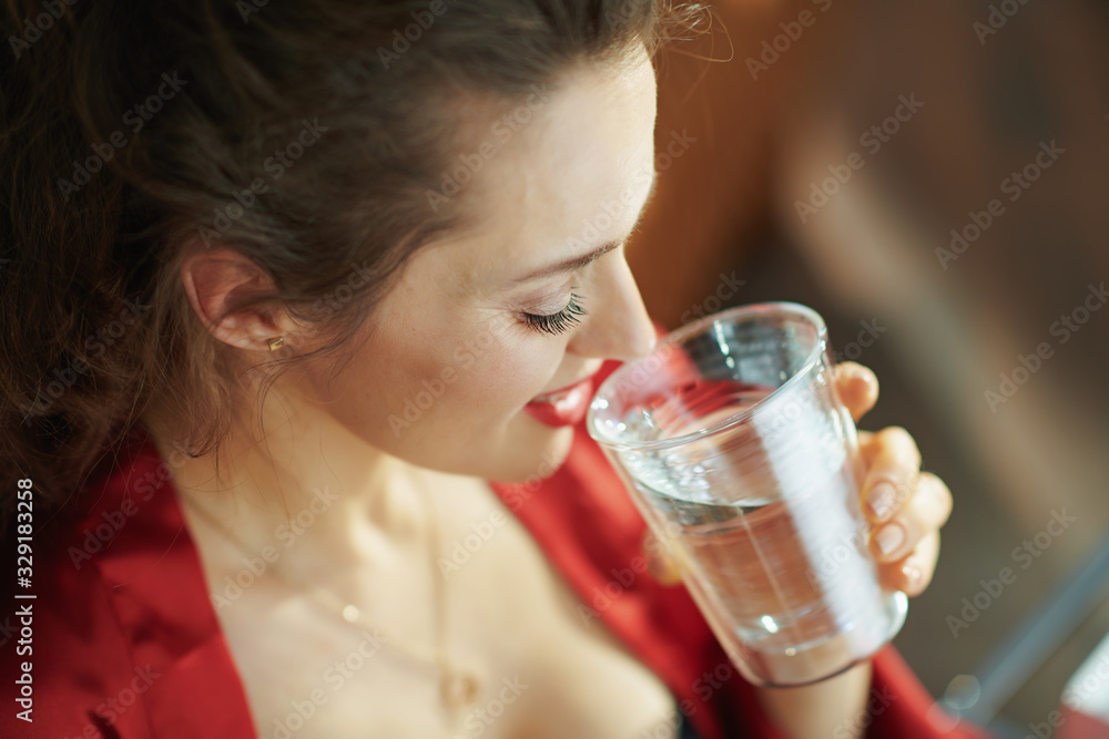 woman in modern house in sunny day drinking cup of water woman in modern house in sunny day drinking cup of water