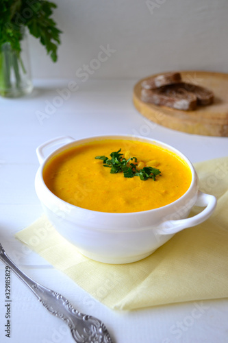 Corn soup with parsley and bread on a white background