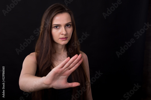 No, this is a failure! Young woman makes a hand gesture forward sign of failure and denial. She is experiencing negative emotions, standing on a black background.