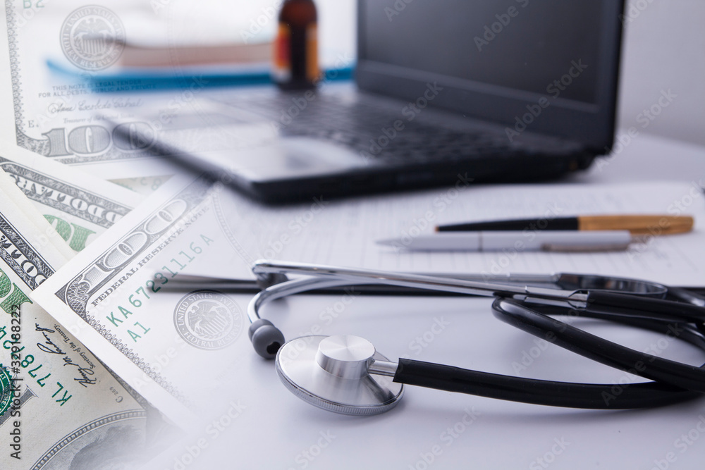 Close-up stethoscope on the background of the doctor’s desktop with laptop and documents. Medical concept Close-up stethoscope on the background of the doctor’s desktop with laptop and documents. Medical concept