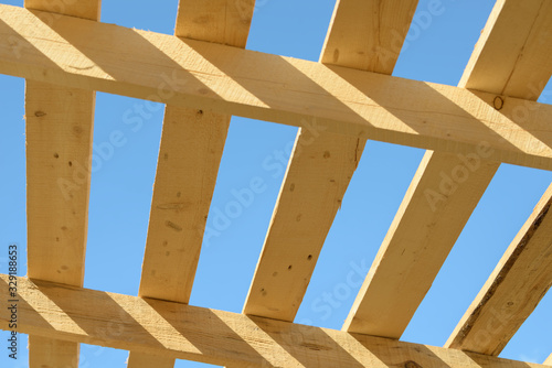 Wood board assembled on construction site. New frame structure of building. Scaffolding framework made from natural materials. Wooden floor or ceiling. Elements and components of the construction.