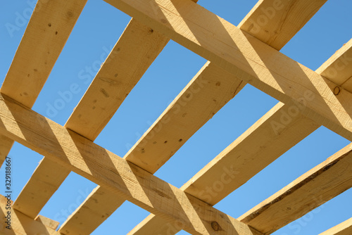 Wood board assembled on construction site. New frame structure of building. Scaffolding framework made from natural materials. Wooden floor or ceiling. Elements and components of the construction.