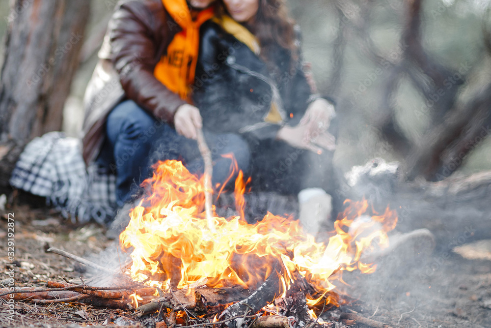 A guy with a girl fry marshmallows on fire. A guy with a girl fry marshmallows on fire.
