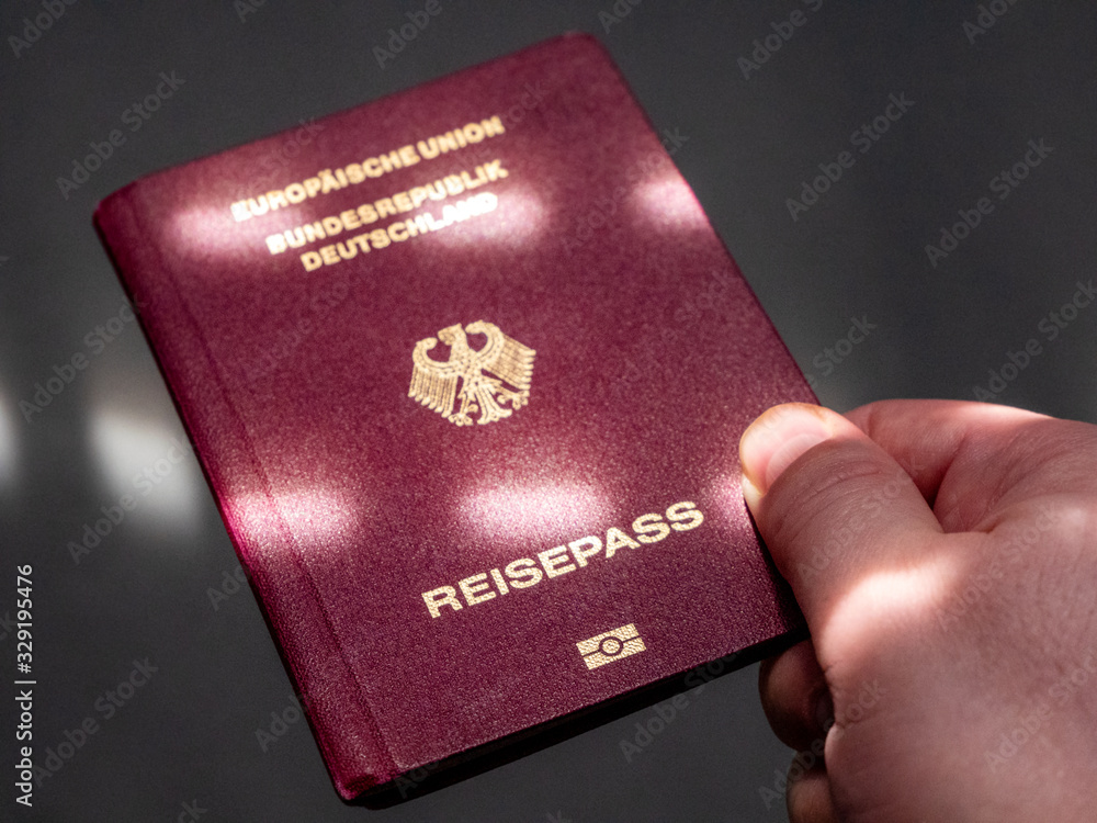 German passport in male hand on check in. Concept Idea German passport in male hand on check in. Concept Idea