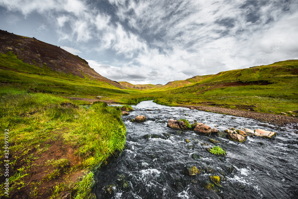Wonderful icelandic nature landscape. View from the top. High mountains, mountain river and green grassland. Green meadows. Iceland. Wonderful icelandic nature landscape. View from the top. High mountains, mountain river and green grassland. Green meadows. Iceland.