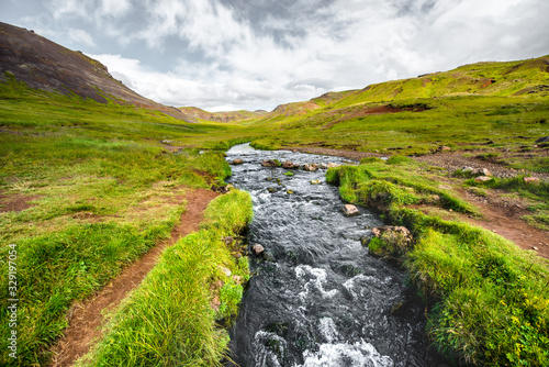 Wonderful icelandic nature landscape. View from the top. High mountains, mountain river and green grassland. Green meadows. Iceland.