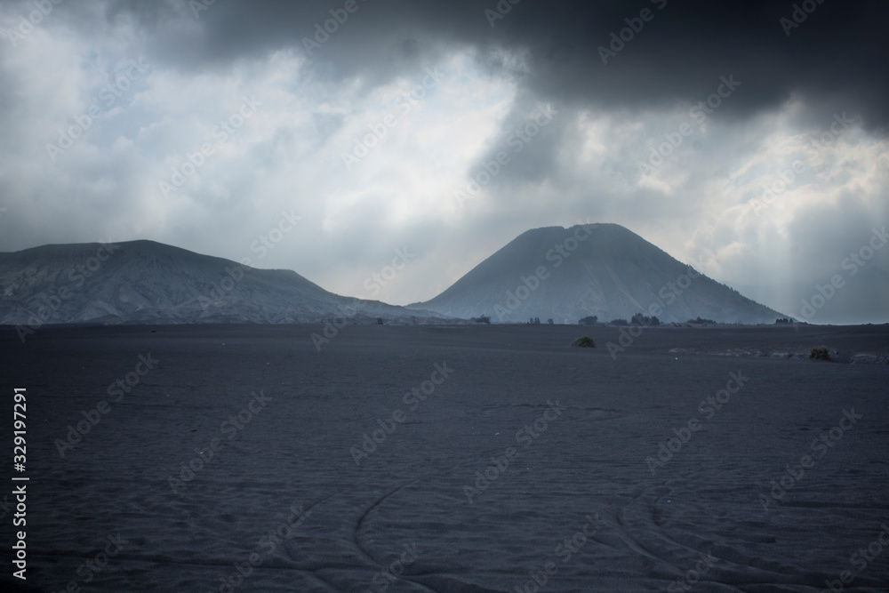 the view of Mount Bromo is illuminated by the sun when it is cloudy