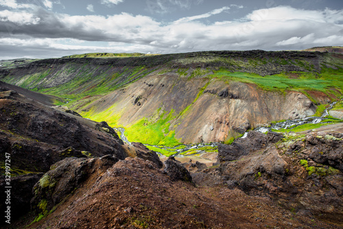Wonderful icelandic nature landscape. View from the top. High mountains, mountain river and green grassland. Green meadows. Iceland.