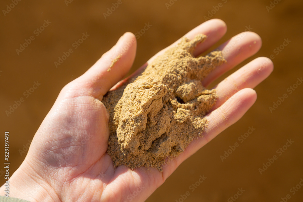 Hand of a young women holding raw clay for plastering Hand of a young women holding raw clay for plastering