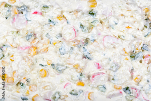 Salad with egg, canned corn, crab sticks, fresh cucumber and mayonnaise. Texture