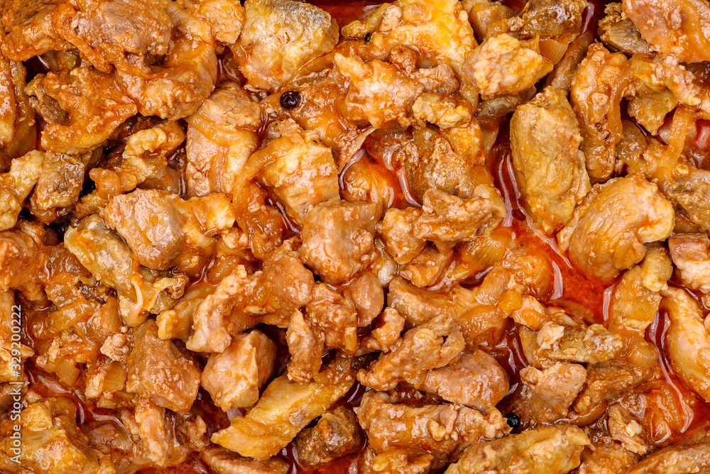 Stewed pork pieces with onions in tomato sauce with paprika. Texture Stewed pork pieces with onions in tomato sauce with paprika. Texture