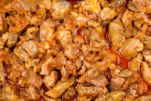 Stewed pork pieces with onions in tomato sauce with paprika. Texture