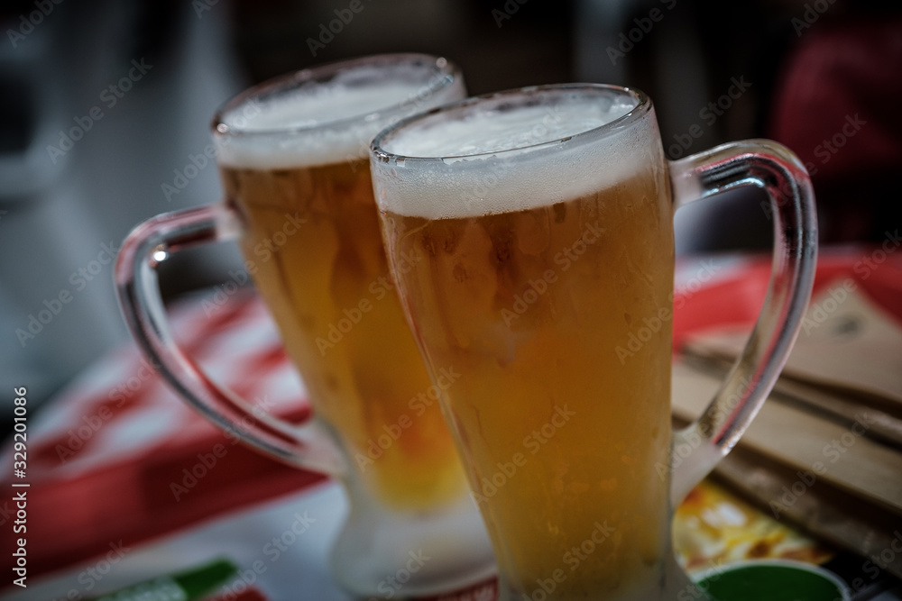 Two glasses of icecold beer on a table