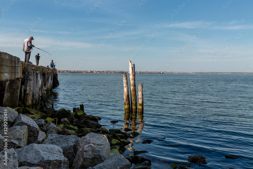 man standing on pier and looking at the sea