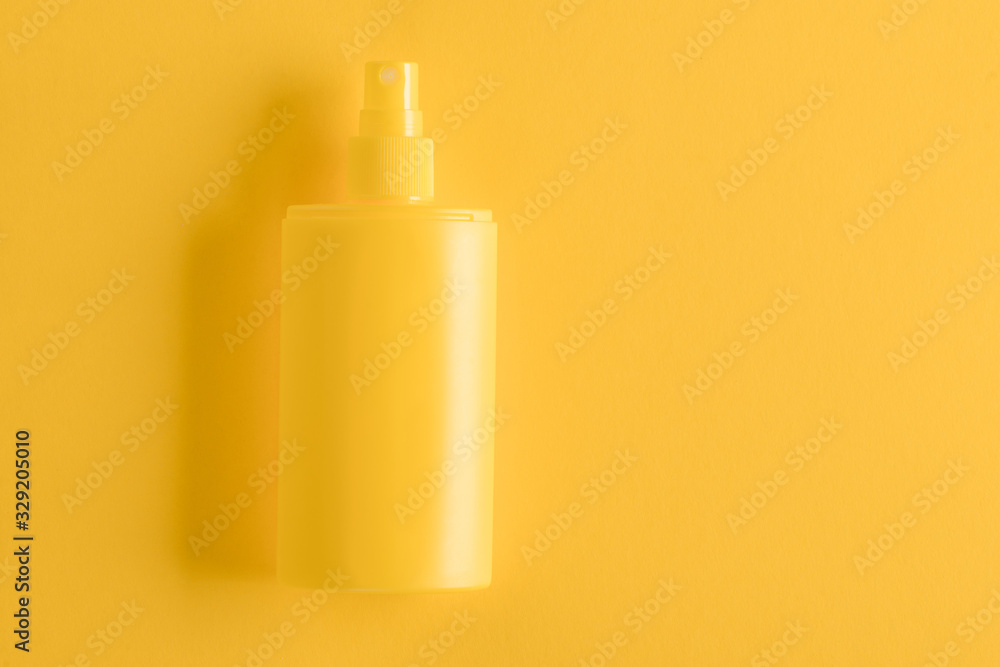 Sunscreen spray on yellow background Sunscreen spray on yellow background