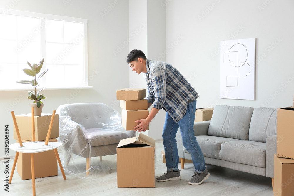 Asian man with belongings at home on moving day Asian man with belongings at home on moving day