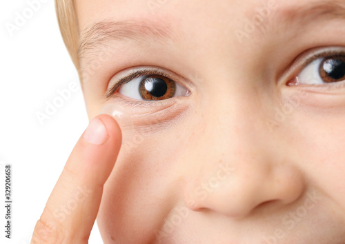 Little boy putting in contact lens, closeup