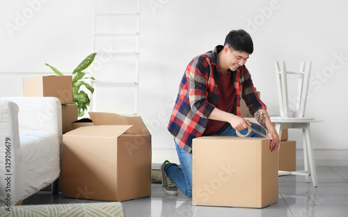 Asian man packing things on moving day