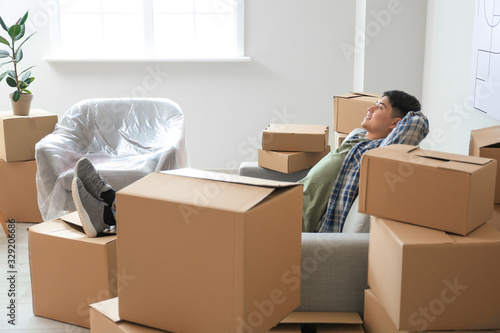 Asian man relaxing at home on moving day