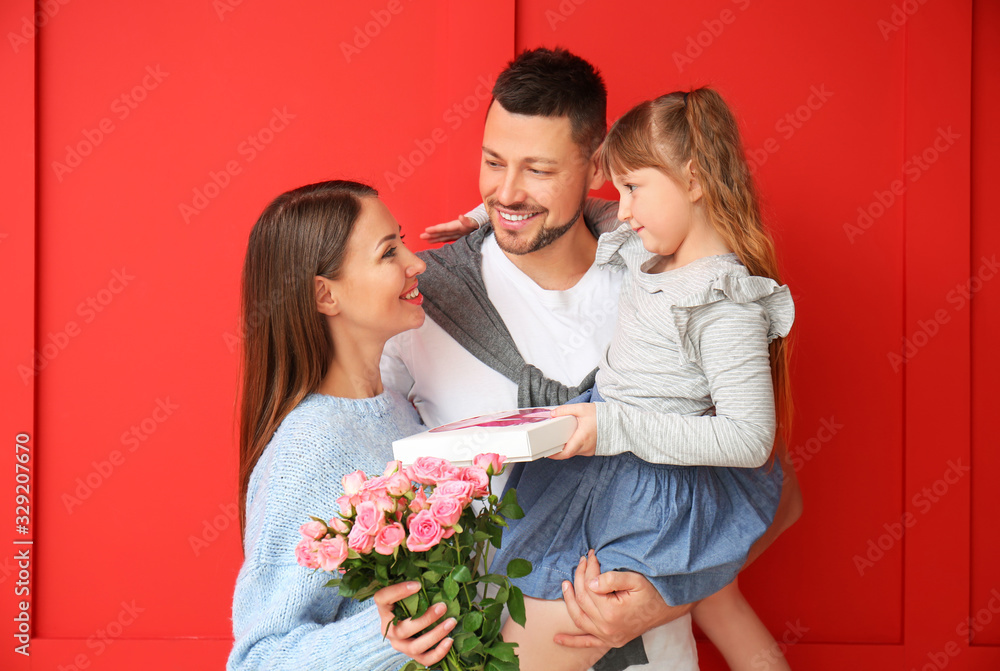 Husband and little daughter greeting woman to Mother's Day on color background Husband and little daughter greeting woman to Mother's Day on color background
